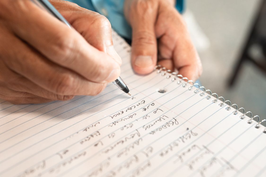 Hands writing notes in a notebook