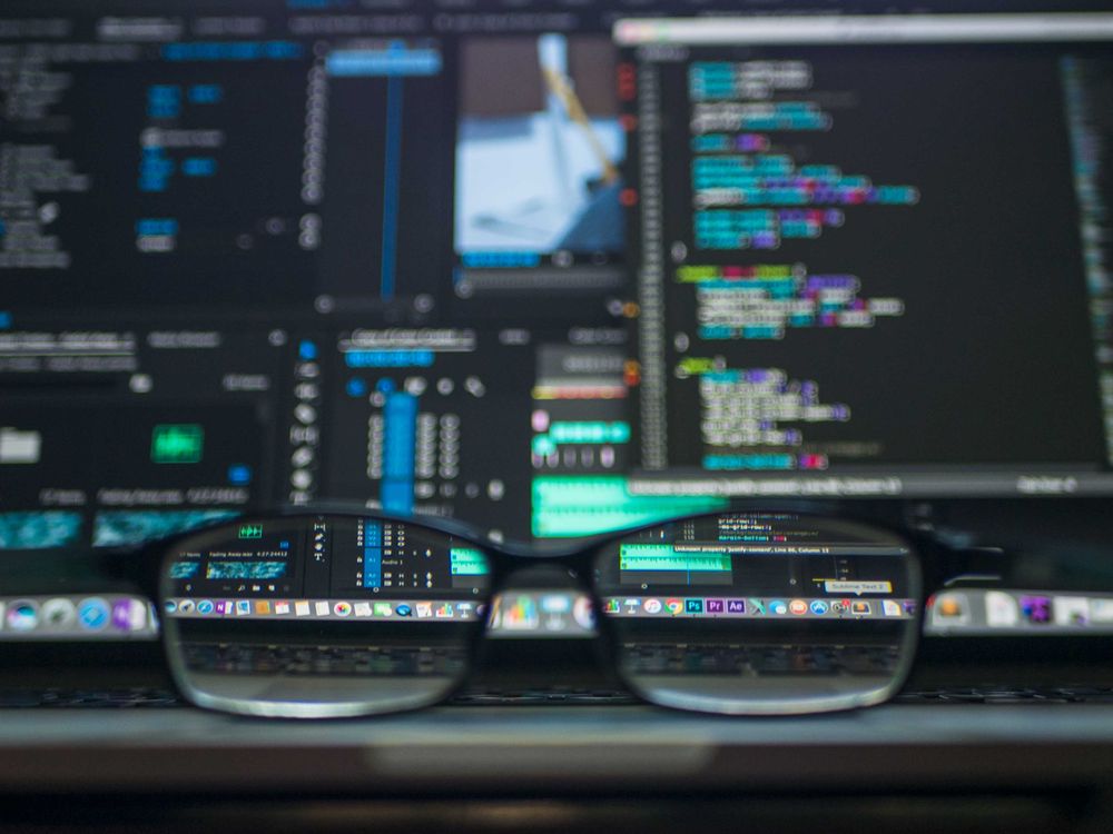 Code on a screen reflected in eyeglasses